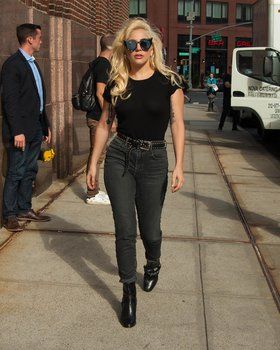 a woman walking down the street wearing black boots