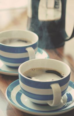 two blue and white coffee cups sitting on top of a table next to each other