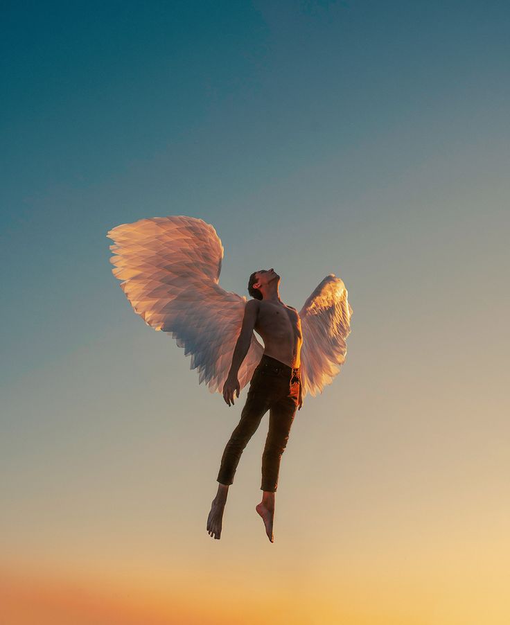 a man flying through the air while holding onto an angel's wings in front of a sunset