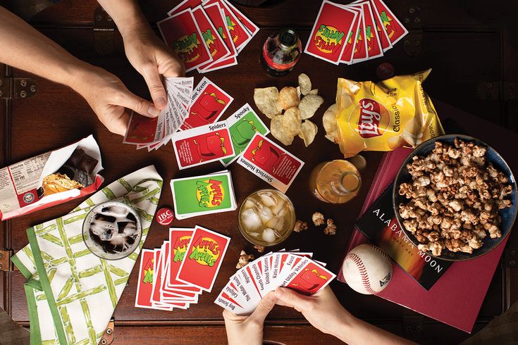 people playing cards and snacks on a table