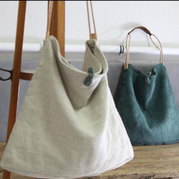 two purses sitting on top of a wooden table