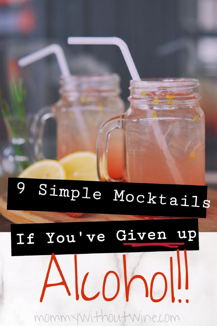 two mason jars filled with drinks sitting on top of a wooden table next to lemons