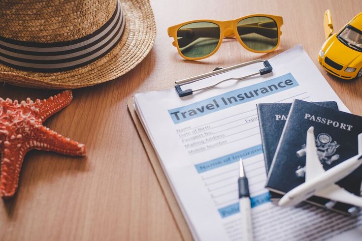 a passport, sunglasses, and starfish sit on a table next to a hat