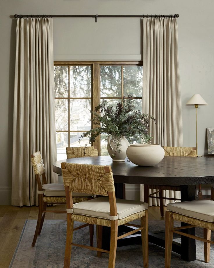 a dining room table with chairs and a vase on it