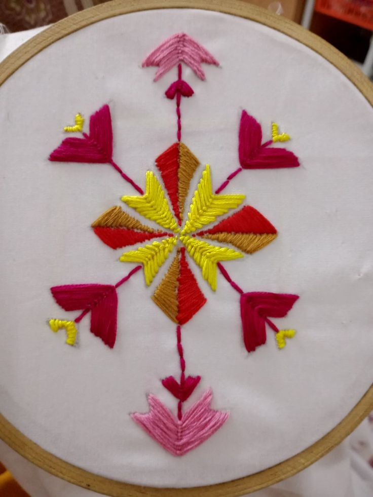 a close up of a embroidery on a piece of cloth with an embroidered design in the middle