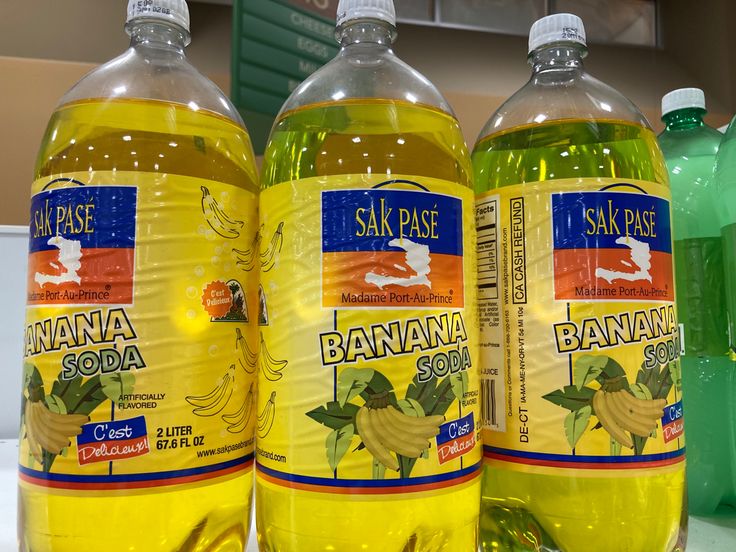 three bottles of banana soda sitting on top of a counter