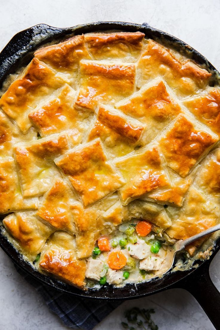 a chicken pot pie in a cast iron skillet with a serving utensil