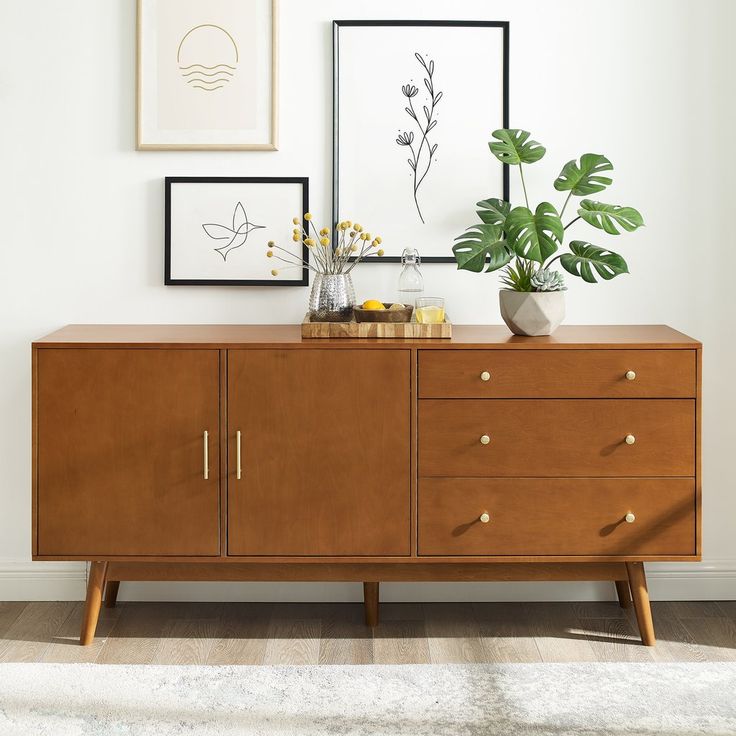 a wooden dresser with two plants on top