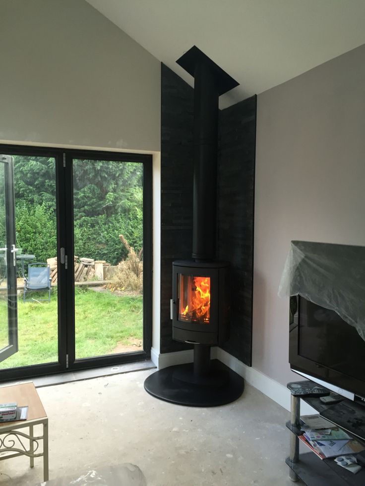 a living room with a fire place in the center and sliding glass doors leading outside