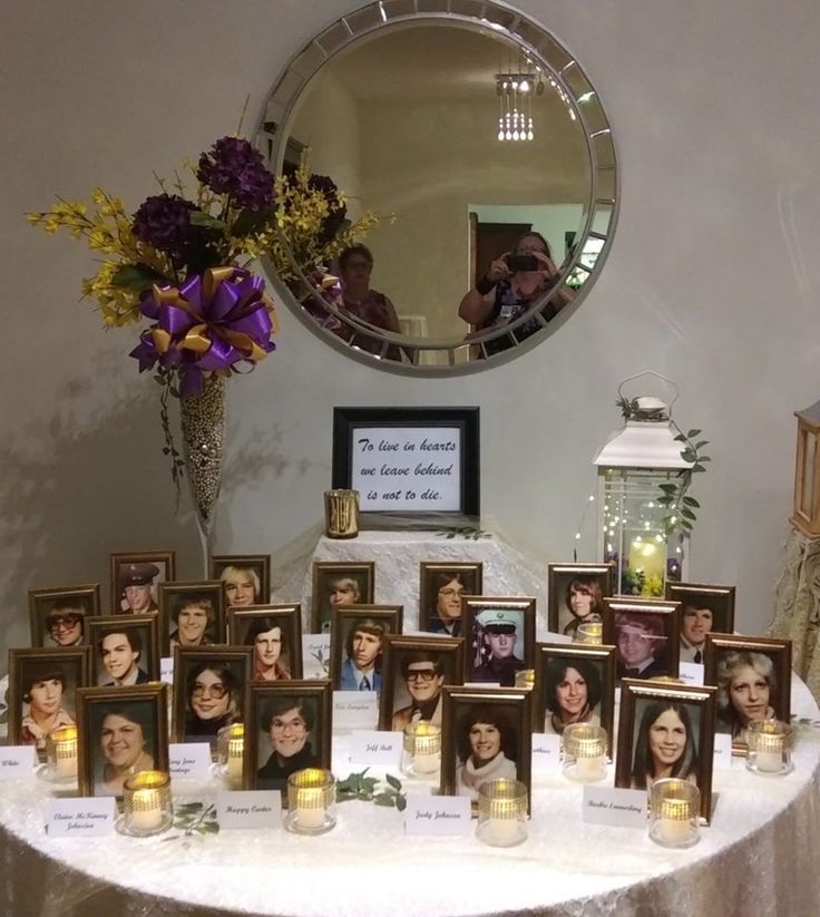 a table topped with pictures and candles next to a mirror