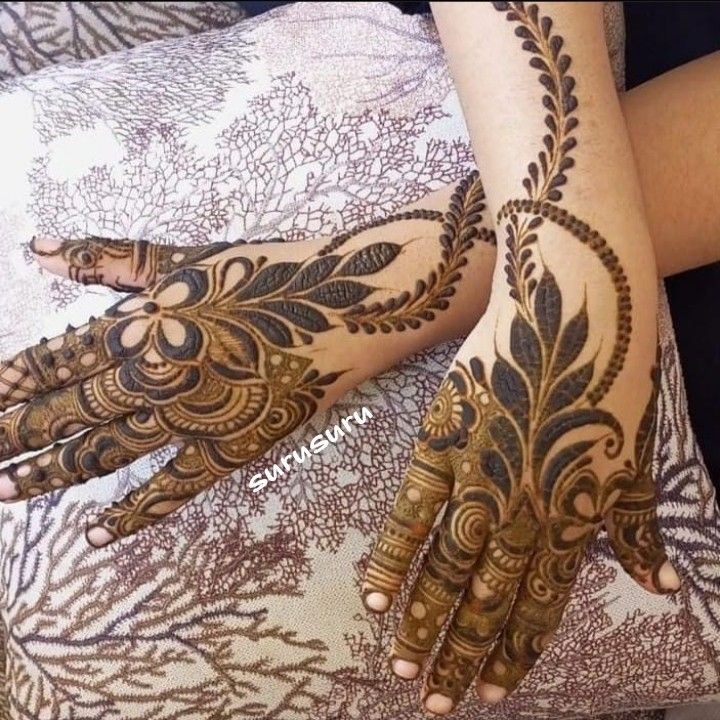 two hands with henna tattoos on them