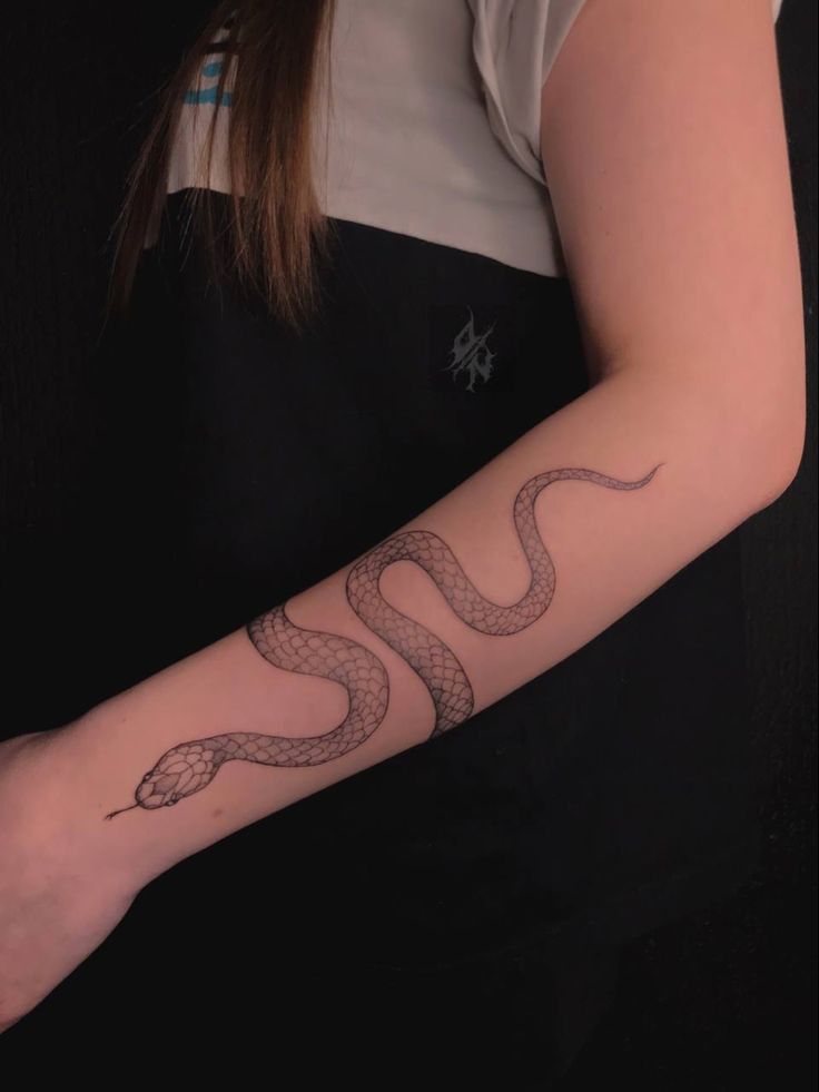 a woman with a snake tattoo on her arm