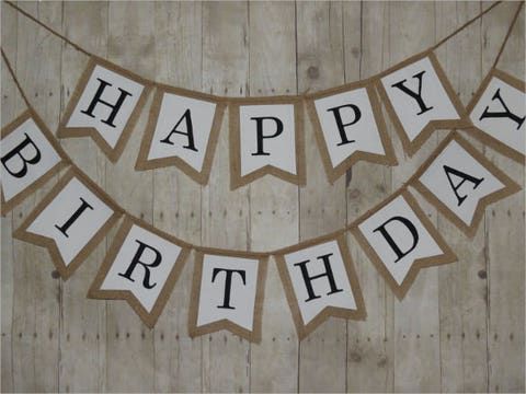 a happy birthday banner hanging on a wooden wall