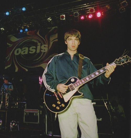 a young man playing an electric guitar on stage