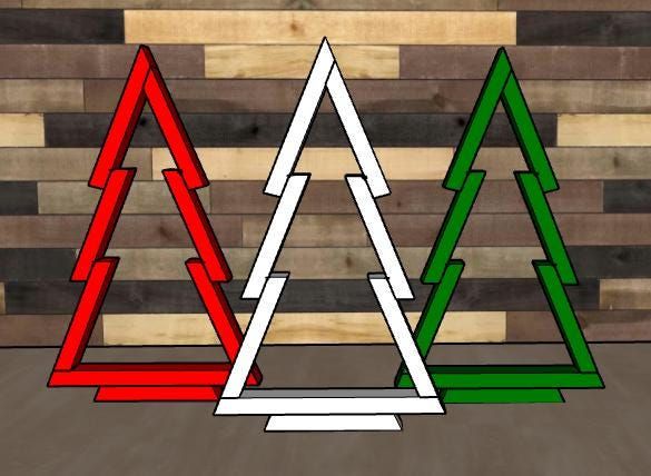 three different colored christmas trees sitting on top of each other in front of wood planks