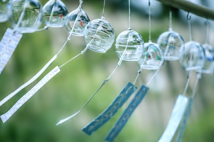 some glass balls hanging from a tree branch with tags attached to the strings that hang on them