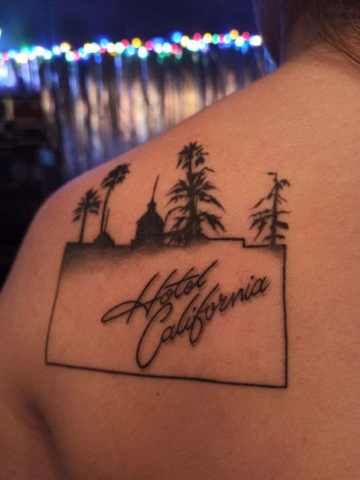 the back of a woman's shoulder with a tattoo that reads, happy california