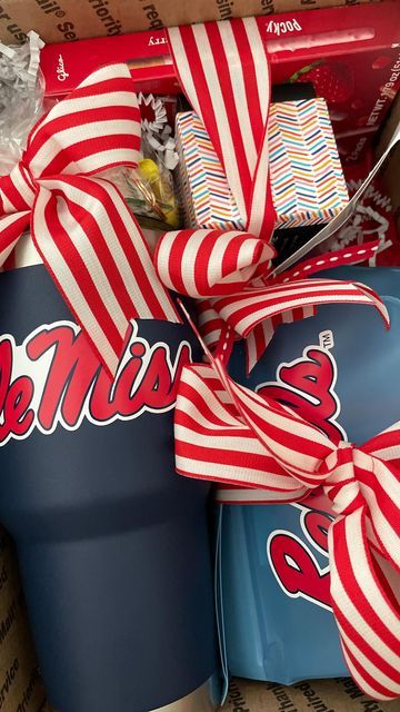 a box filled with candy and wrapped in red and white striped ribbon, sitting on top of a cardboard box