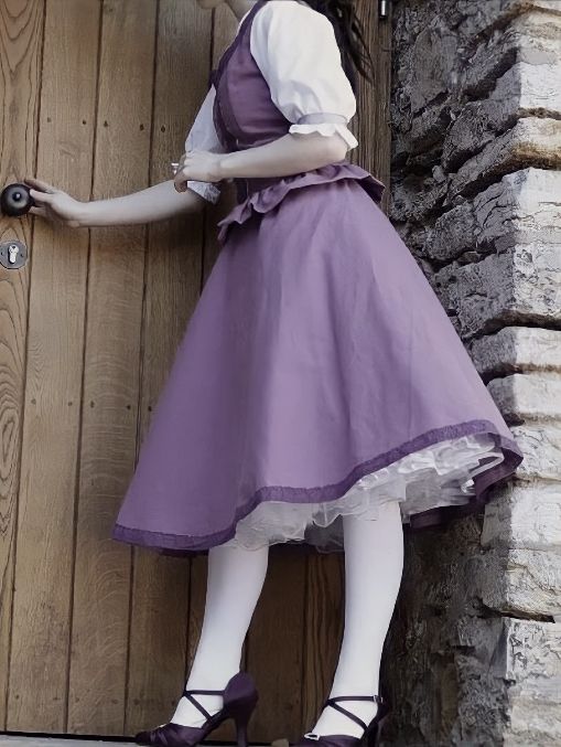 a woman in a purple dress is leaning against a door