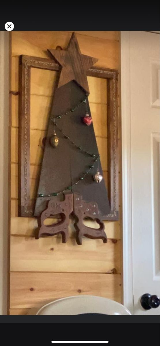 a wooden christmas tree hanging on the wall