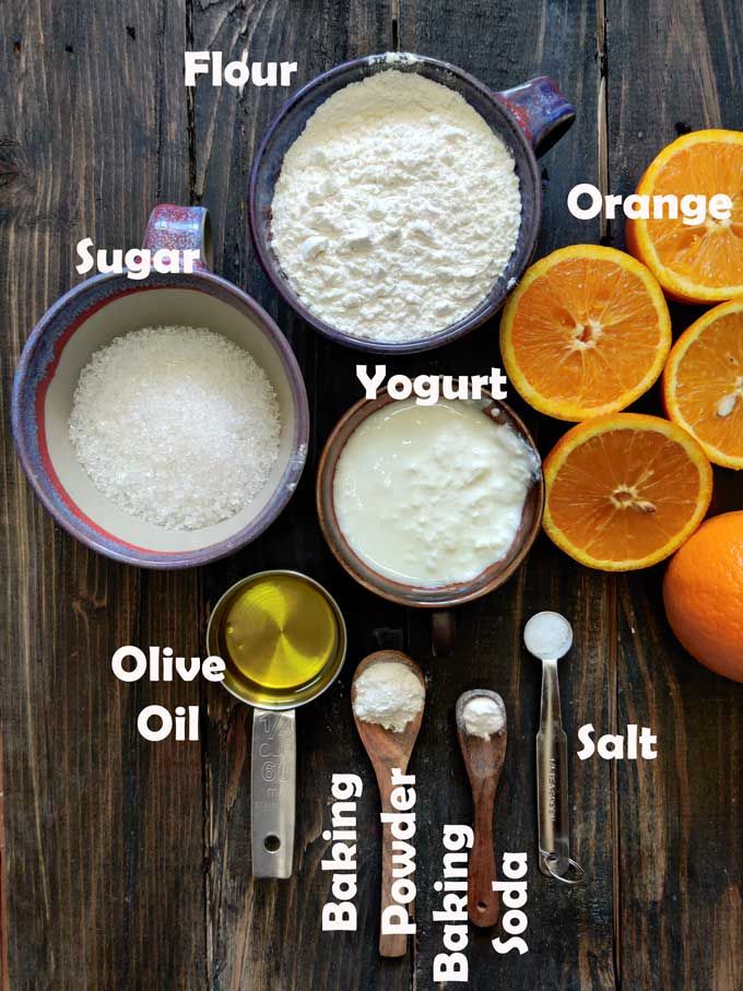 ingredients to make orange cake laid out on a wooden table