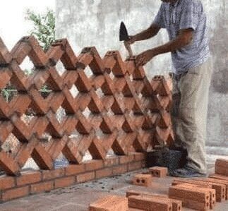 a man is working on a brick wall with a hammer and bricks laid around it