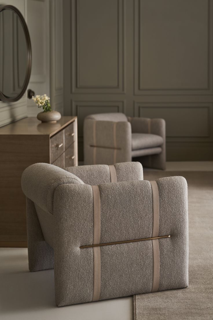 a living room filled with furniture next to a dresser and chair in front of a mirror