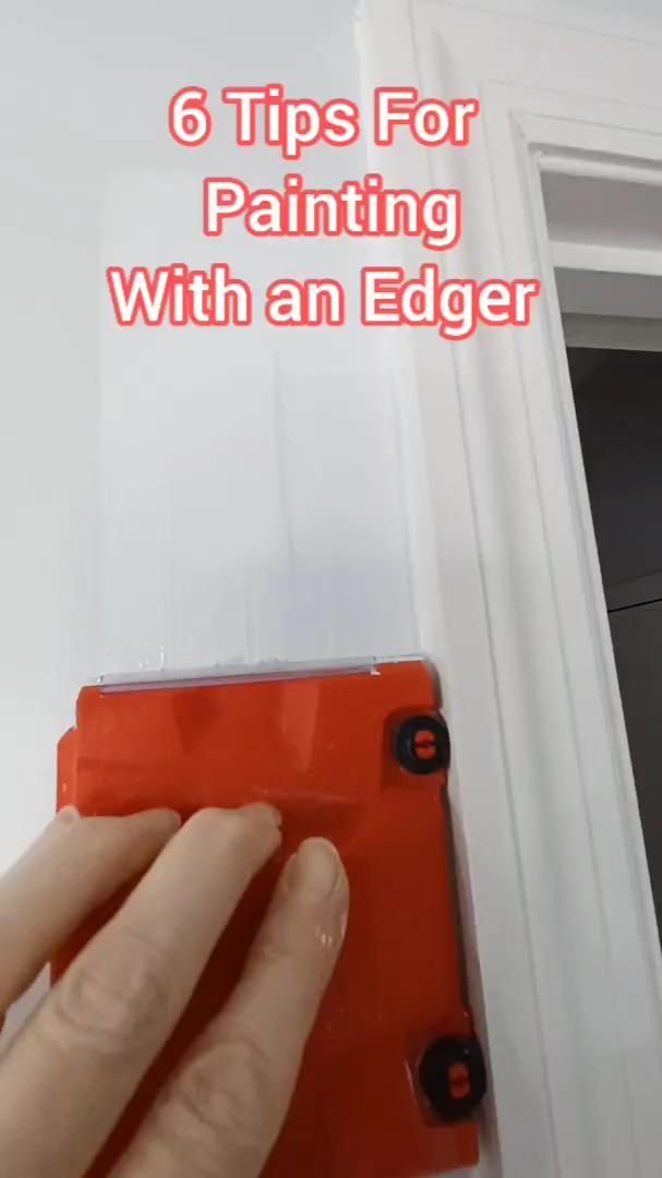 someone is painting the door with an edger on their hand and pointing at it