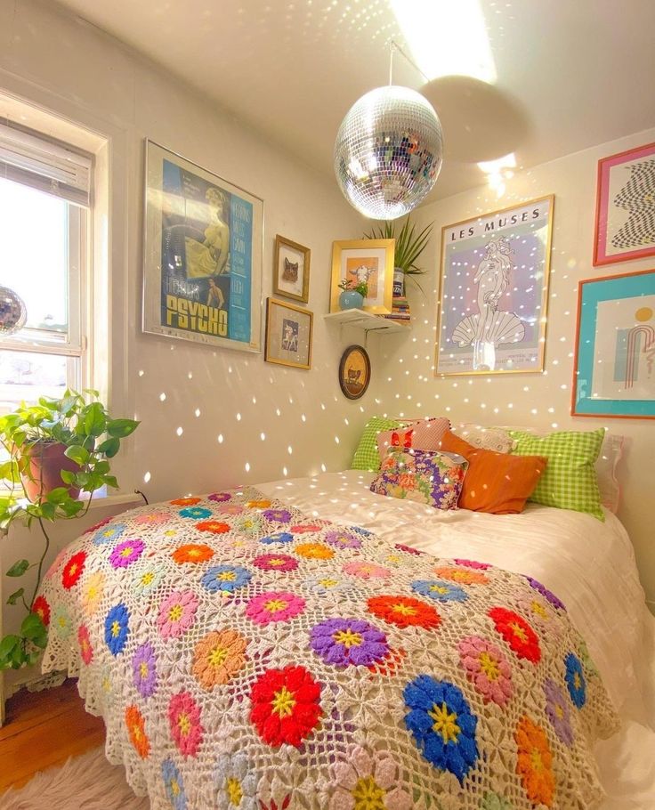 a bed with a crocheted blanket and colorful pillows