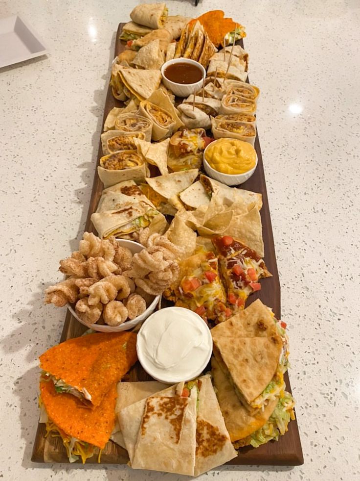 a long table filled with different types of food and dipping sauces on top of it