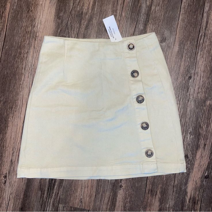 Unworn. Cream. Stretchy. Spring Skort With Button Closure And Short Length, Summer Mini Skirt With Button Closure, Spring Button-up Mini Skirt, Spring Short Skirt With Buttons, Buttoned Mini Skirt For Summer, Chic Buttoned Skort For Spring, Fitted Button-up Skort For Spring, Fitted Button Skort For Summer, Fitted Buttoned Skort For Summer