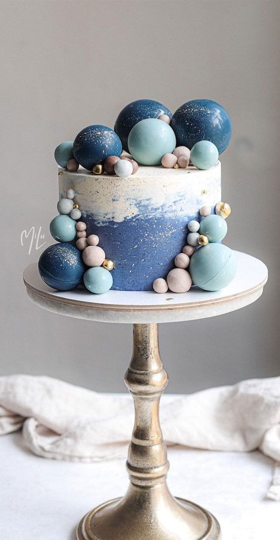 a cake with blue and white frosting sitting on top of a table