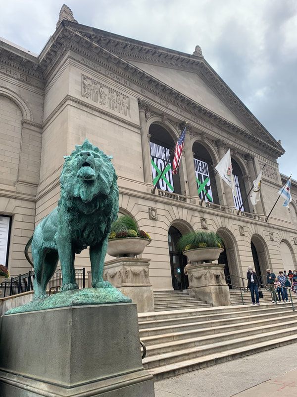 there is a statue of a lion in front of a building with flags on it