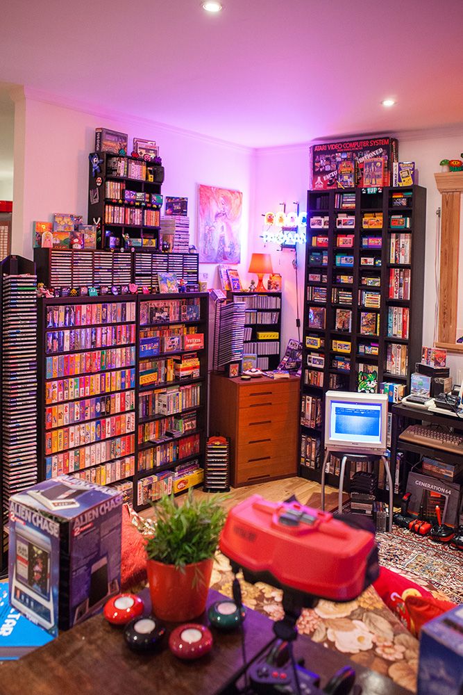 a room filled with lots of video game equipment and games on the shelves in front of them