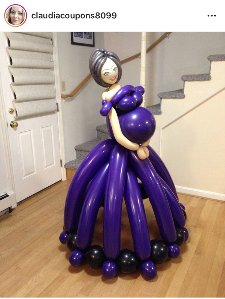 an inflatable balloon sculpture sitting on top of a wooden floor next to stairs