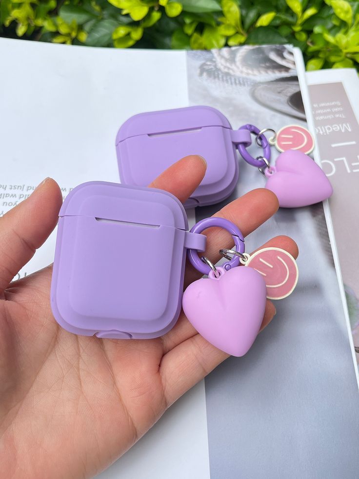 two purple heart shaped airpods sitting on top of each other