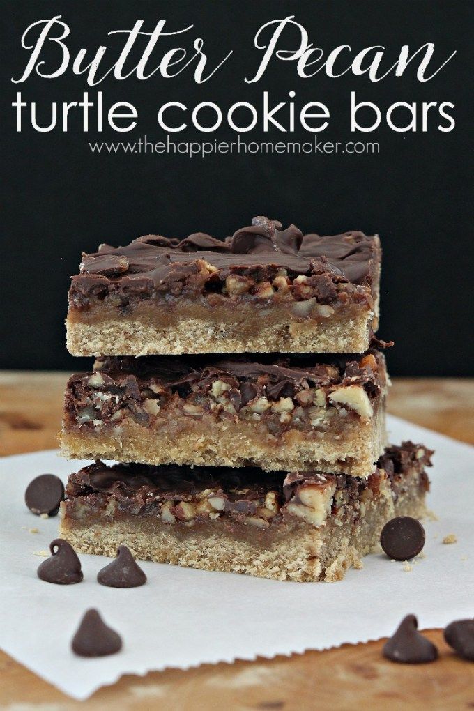 three pieces of chocolate peanut butter pecan turtle cookie bars stacked on top of each other