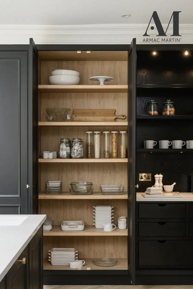 an open bookcase in the middle of a kitchen with black cabinets and white counter tops