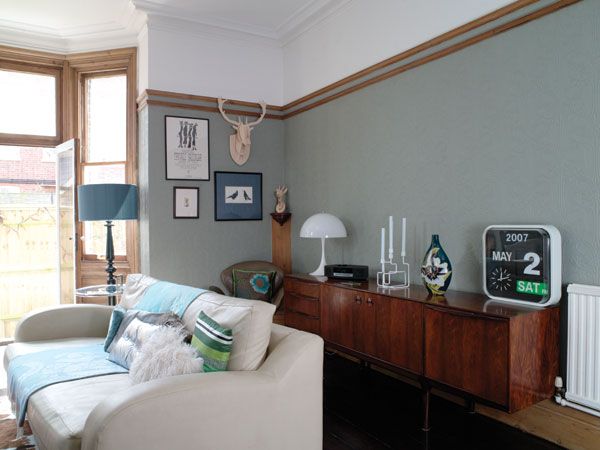 a living room filled with furniture next to a window and a lamp on top of a table