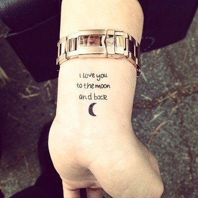 a person with a wrist tattoo that says i love you to the moon and back