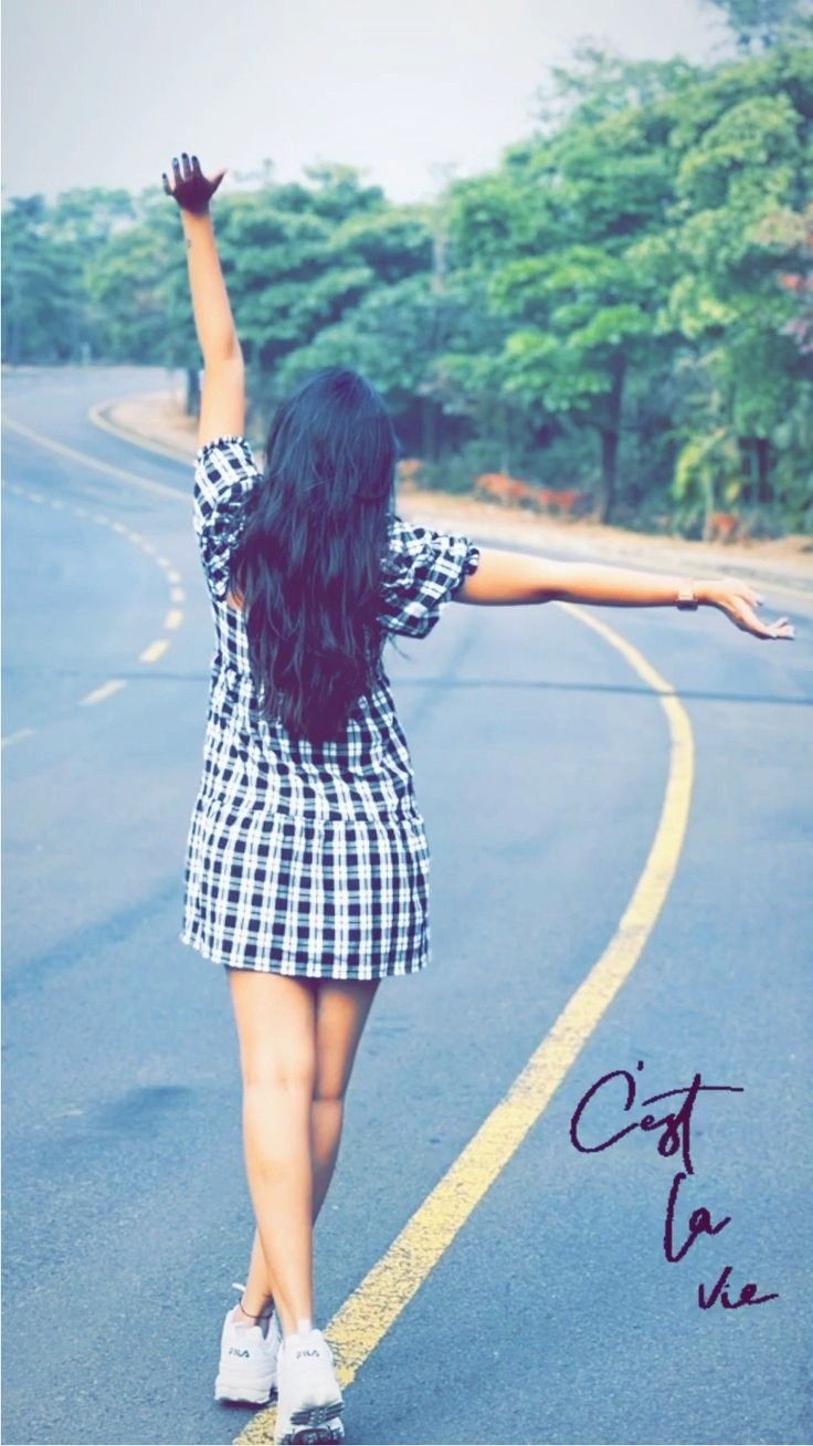 a woman walking down the road with her arms outstretched