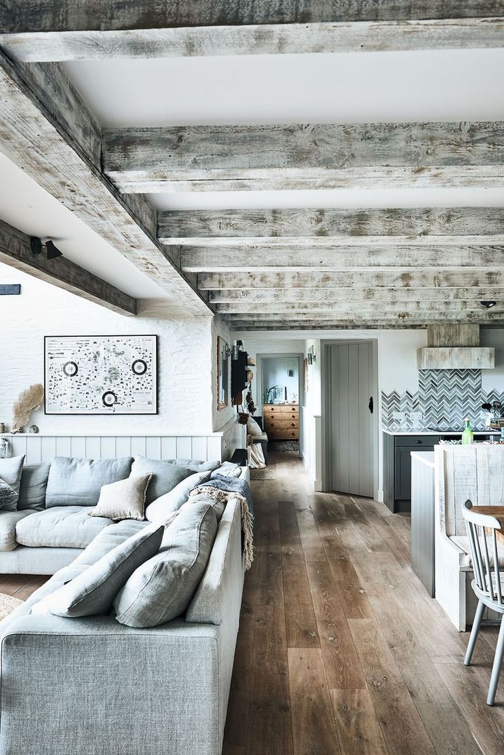 a living room filled with furniture next to a kitchen