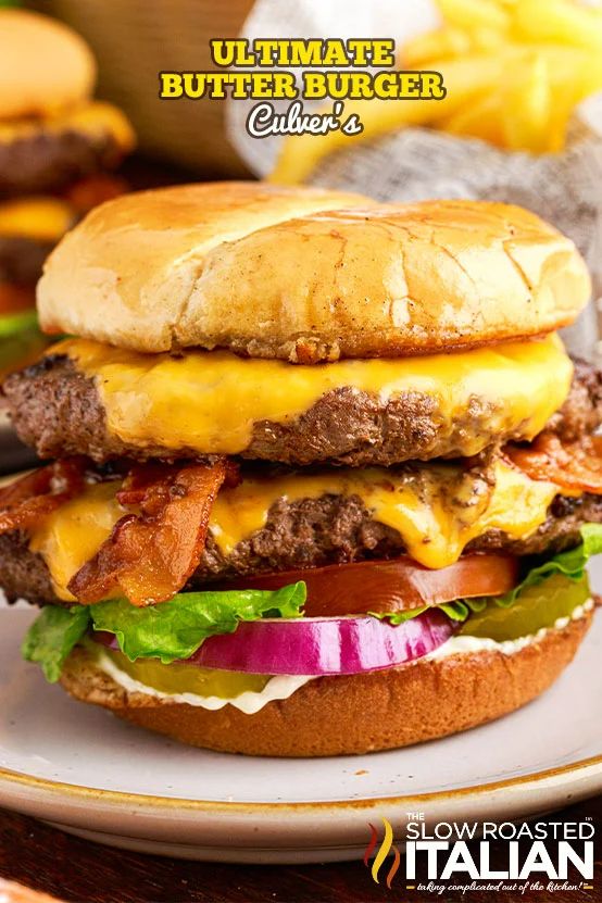 a cheeseburger with bacon, lettuce and tomato on it sitting on a plate