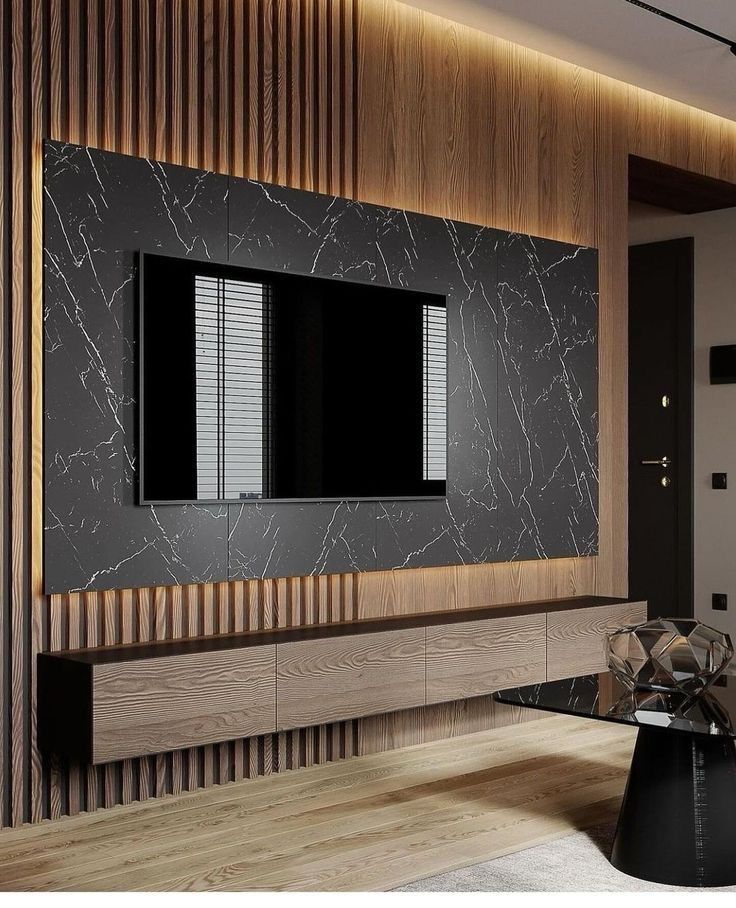 a modern living room with black and white marble on the wall, wood paneling