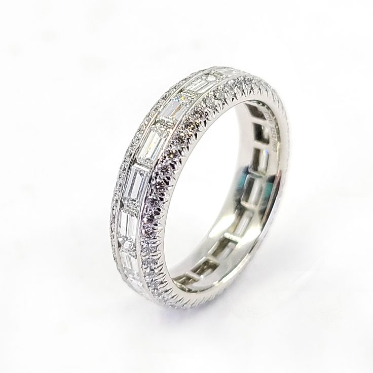 This JB Star eternity band is crafted in platinum and features 18 horizontal emerald cut diamonds of VS Clarity and G Color totaling 1.94 Carats. Accenting the emerald cut diamonds are 94 round brilliant cut diamonds of VS Clarity and G Color totaling 0.71 Carats. Finger size 5.5, this ring includes the original certificate of authenticity. Emerald Cut Cubic Zirconia Eternity Band With Baguette Diamonds, Emerald Cut Diamond Eternity Band With Baguette Diamonds, Emerald Cut Baguette Diamond Eternity Band, White Gold Octagon Diamond Ring With Baguettes, Octagon White Gold Diamond Ring With Baguette Diamonds, White Gold Octagon Diamond Ring With Baguette Diamonds, Diamond White Eternity Band With Baguette Diamonds, Diamond White Baguette Cut Diamond Eternity Band, Silver Emerald Cut Eternity Band With Diamond Cut