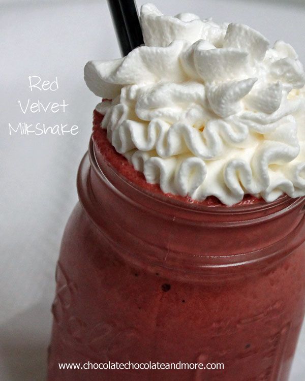 a red velvet milkshake with whipped cream and black straw in a mason jar