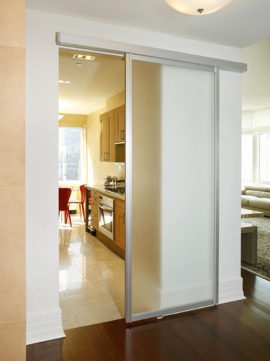 an open sliding door in a living room next to a kitchen and dining room area