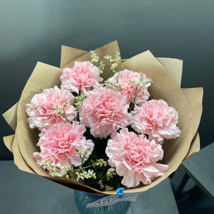 a bouquet of pink carnations in a blue vase