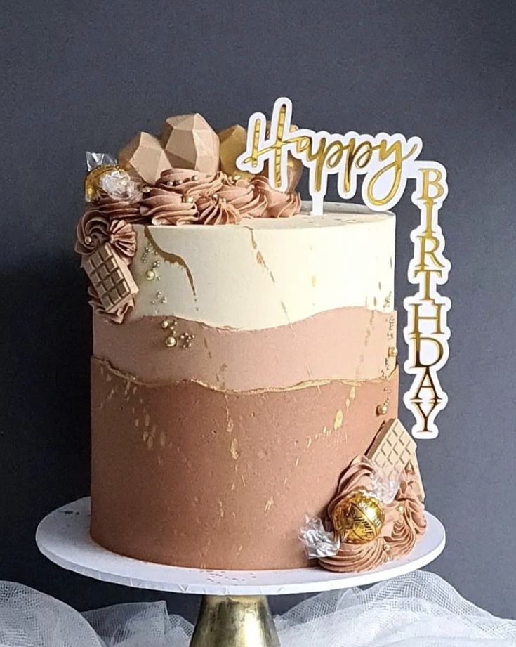 a birthday cake decorated with gold and pink icing