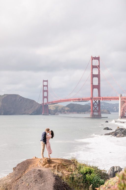 a couple kissing in front of the golden gate bridge